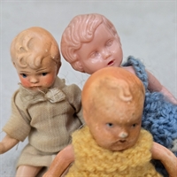 keramikdukker-gul-kjole-beige-toej-plastikdukke-blaa-strikkjole-gammelt-legetoej